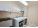 Laundry room with modern washer and dryer, storage shelves, and tiled floors at 4902 Guysborough St, Las Vegas, NV 89148