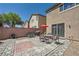 Outdoor patio area with stone pavers, a red umbrella, and seating for outdoor dining at 4902 Guysborough St, Las Vegas, NV 89148