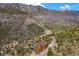 Birds eye view of stunning multi-home mountain community with beautiful green trees and winding roads through the terrain at 4927 Snow White Rd, Las Vegas, NV 89124
