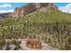 Unique multi-story log cabin home nestled against a mountain with lush green trees and winding road at 4927 Snow White Rd, Las Vegas, NV 89124