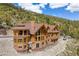 A scenic multi-story log home with architectural roof lines, and surrounded by tall trees at 4927 Snow White Rd, Las Vegas, NV 89124