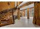 Grand foyer showcases a wooden staircase with wrought iron detailing and log beam accents at 4927 Snow White Rd, Las Vegas, NV 89124