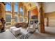 Stunning log home living room featuring floor-to-ceiling windows, fireplace, and exposed wood beams at 4927 Snow White Rd, Las Vegas, NV 89124