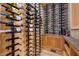 Custom wine cellar with wooden cabinets, stone accent wall, and metal wine racks at 4927 Snow White Rd, Las Vegas, NV 89124