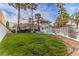 Expansive backyard featuring green grass, mature trees, and home exterior at 4944 Spanish Heights Dr, Las Vegas, NV 89148