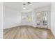 Bright and spacious bedroom with light wood floors, plantation shutters, and a ceiling fan, showcasing a minimalist design at 4944 Spanish Heights Dr, Las Vegas, NV 89148
