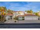 Stunning two-story home with a red tile roof, three-car garage, porte-cochère, and lush landscaping at 4944 Spanish Heights Dr, Las Vegas, NV 89148