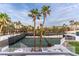 View of the community tennis court and surrounding palm trees from the home's patio area at 4944 Spanish Heights Dr, Las Vegas, NV 89148