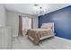Bedroom featuring wooden floors, modern lighting fixture and dark blue accent wall at 5045 Sock Hop Way, North Las Vegas, NV 89031
