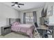 Bedroom with ceiling fan, desk, and window with grey curtains at 5045 Sock Hop Way, North Las Vegas, NV 89031
