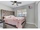 Bedroom with ceiling fan, window, light grey walls, and a pink bedspread at 5045 Sock Hop Way, North Las Vegas, NV 89031