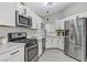 Bright kitchen featuring white cabinets, stainless appliances, and a stylish modern design at 5045 Sock Hop Way, North Las Vegas, NV 89031