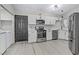 Clean kitchen with stainless steel appliances, white cabinets, and wood-look tile flooring at 5045 Sock Hop Way, North Las Vegas, NV 89031