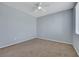Clean bedroom has neutral carpet, ample natural light, and a fan at 5078 Rivedro St, Las Vegas, NV 89135