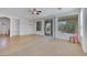 Bright living room with tile and carpet flooring, ceiling fan, and sliding glass doors to the outside patio at 5078 Rivedro St, Las Vegas, NV 89135