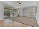 Spacious living room features a ceiling fan, access to backyard through sliding doors, and tile/carpet flooring at 5078 Rivedro St, Las Vegas, NV 89135