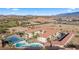 Wide aerial of resort condos in a desert community featuring a tennis court, pool, parking, and picturesque desert views at 555 Highland Dr # 203, Mesquite, NV 89027