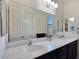 Modern bathroom featuring a double sink vanity with granite countertops and a large mirror at 6975 Hopi Summit Ct, Las Vegas, NV 89149
