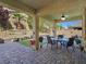 Attractive outdoor patio space with seating, dining table, and well-maintained landscaping at 6975 Hopi Summit Ct, Las Vegas, NV 89149