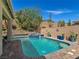 Inviting backyard pool and spa with desert landscaping and a blue tiled trim are perfect for hot summer days at 6975 Hopi Summit Ct, Las Vegas, NV 89149