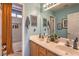Well-lit bathroom with double sinks, a large mirror, and a separate toilet and shower area at 7352 Rietz Canyon St, Las Vegas, NV 89131