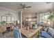 Open dining room with a wooden table, blue chairs, and views into the bright kitchen at 7352 Rietz Canyon St, Las Vegas, NV 89131