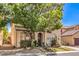 Inviting two-story home with a tile roof, mature tree, and cozy front porch seating area at 7352 Rietz Canyon St, Las Vegas, NV 89131
