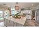 Bright kitchen featuring white cabinets, a large center island, modern appliances, and an open view to the backyard at 7352 Rietz Canyon St, Las Vegas, NV 89131