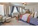 Bright main bedroom featuring two windows, a ceiling fan, dresser, and accent seating at 7352 Rietz Canyon St, Las Vegas, NV 89131