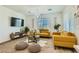 Bright living room with modern furnishings, including yellow couches and a large-screen TV at 7360 N Decatur Blvd # 1, Las Vegas, NV 89131
