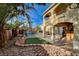 Beautiful backyard with private pool, waterfall feature, patio area and lush landscaping at 7619 Belgian Lion St, Las Vegas, NV 89139