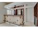 Stylish bar area featuring tiled bar front, mirrored cabinets, and wine storage at 7619 Belgian Lion St, Las Vegas, NV 89139