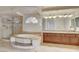Luxurious primary bathroom features a soaking tub, glass shower, and double vanity at 7619 Belgian Lion St, Las Vegas, NV 89139