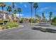 Gated entrance to desert homes, featuring lush landscaping and mature palm trees at 7619 Belgian Lion St, Las Vegas, NV 89139