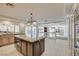 Large kitchen with tile floors, an island with seating, and views into the living room at 7619 Belgian Lion St, Las Vegas, NV 89139