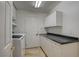Clean laundry room with storage cabinets, granite countertop, and modern appliances at 7619 Belgian Lion St, Las Vegas, NV 89139