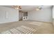 Expansive living room featuring neutral carpet, ceiling fans, and ample natural light at 7619 Belgian Lion St, Las Vegas, NV 89139