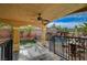 A covered patio provides shade and features a ceiling fan, with a view of a pool and landscaped yard at 7619 Belgian Lion St, Las Vegas, NV 89139
