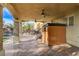 Covered patio features ceiling fans, and outdoor shower with access to a landscaped backyard at 7619 Belgian Lion St, Las Vegas, NV 89139