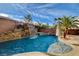 Gorgeous pool area features a rock waterfall, tropical landscaping and a stone coping at 7619 Belgian Lion St, Las Vegas, NV 89139