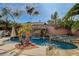 Relaxing swimming pool with a rock waterfall feature, and tropical landscaping at 7619 Belgian Lion St, Las Vegas, NV 89139