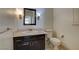 Updated powder room with dark wood vanity, marble counter, and decorative mirror at 7619 Belgian Lion St, Las Vegas, NV 89139