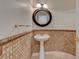 Stylish powder room with pedestal sink, decorative mirror, and tiled wall at 7619 Belgian Lion St, Las Vegas, NV 89139