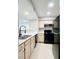 Functional kitchen features modern sink faucet, black appliances and light cabinets at 8101 W Flamingo Rd # 1088, Las Vegas, NV 89147