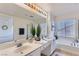 Primary bathroom featuring double sink vanity, soaking tub, and glass enclosed shower at 8143 Retriever Ave, Las Vegas, NV 89147
