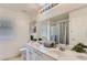 Well-lit bathroom with dual sinks, large mirror, shower-tub combo, and decorative accents at 8143 Retriever Ave, Las Vegas, NV 89147
