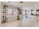 Open living area with an island, tiled floors, large windows with floral curtains and light at 8143 Retriever Ave, Las Vegas, NV 89147