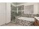 Bathroom showcasing a glass shower, soaking tub with decorative tile, and a vanity at 9048 Faversham Ct, Las Vegas, NV 89123