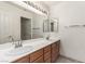 This bathroom features a double sink vanity, white cabinets and a large mirror at 9048 Faversham Ct, Las Vegas, NV 89123