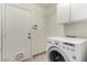 This laundry room features a front load washer and overhead storage at 9048 Faversham Ct, Las Vegas, NV 89123